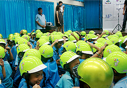 Students receive helmets and instructions on proper helmet use from sponsors