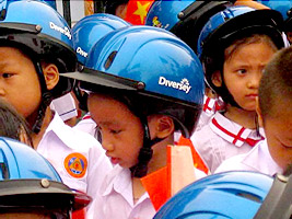 First grade students model their helmets