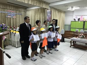 Members of the Department of Disaster Prevention and Mitigation and AIP Foundation Thailand Country Manager Oratai Junsuwanaruk pose with students from Sukhothai School at the helmet handover ceremony.