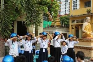  Students from Wat Toul Tompong Primary School use the two finger rule to measure the correct positioning of their helmets. 