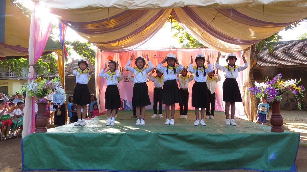 Students participating in a performance with their brand new helmets on stage.